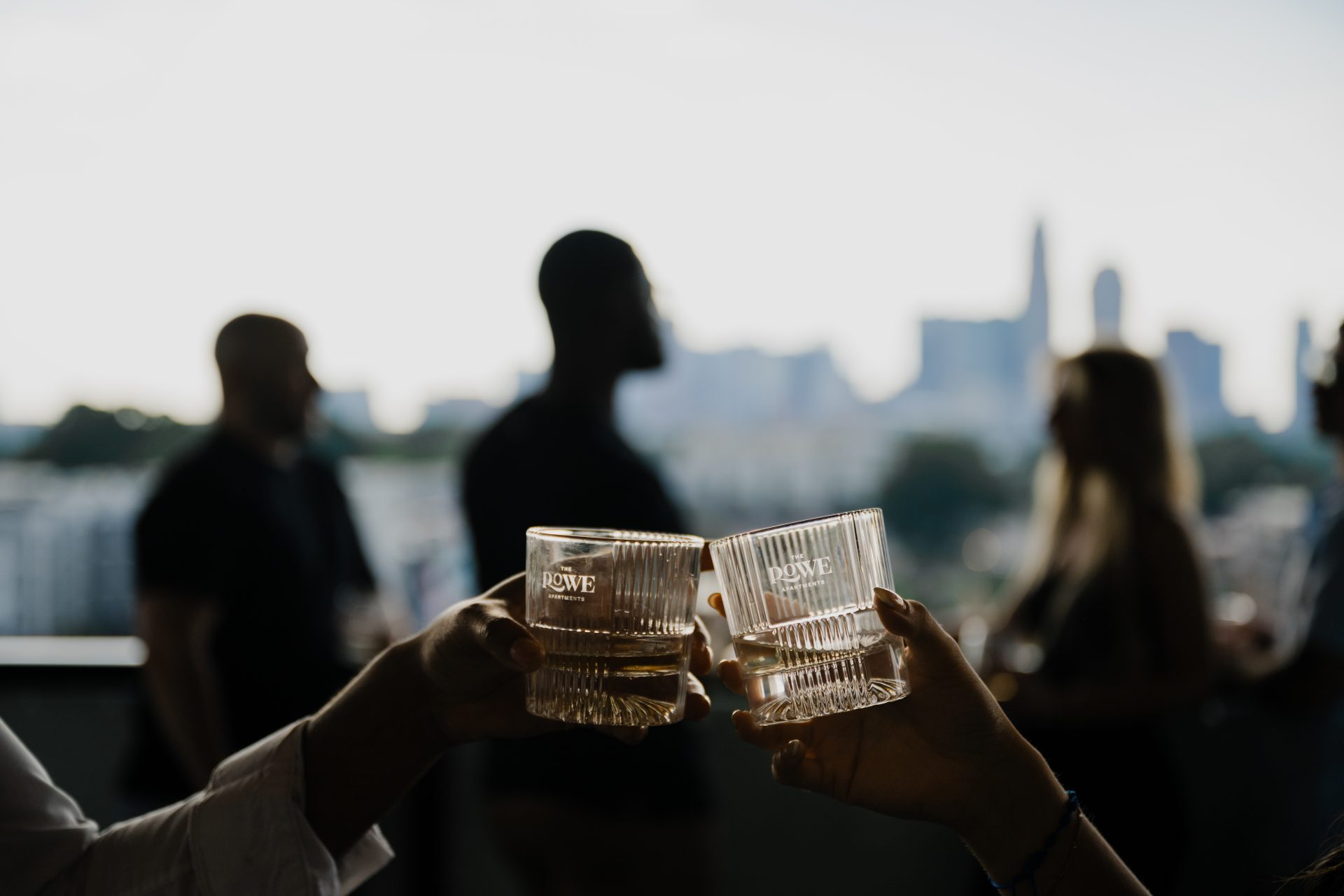 Group of residents socializing on a rooftop terrace at sunset