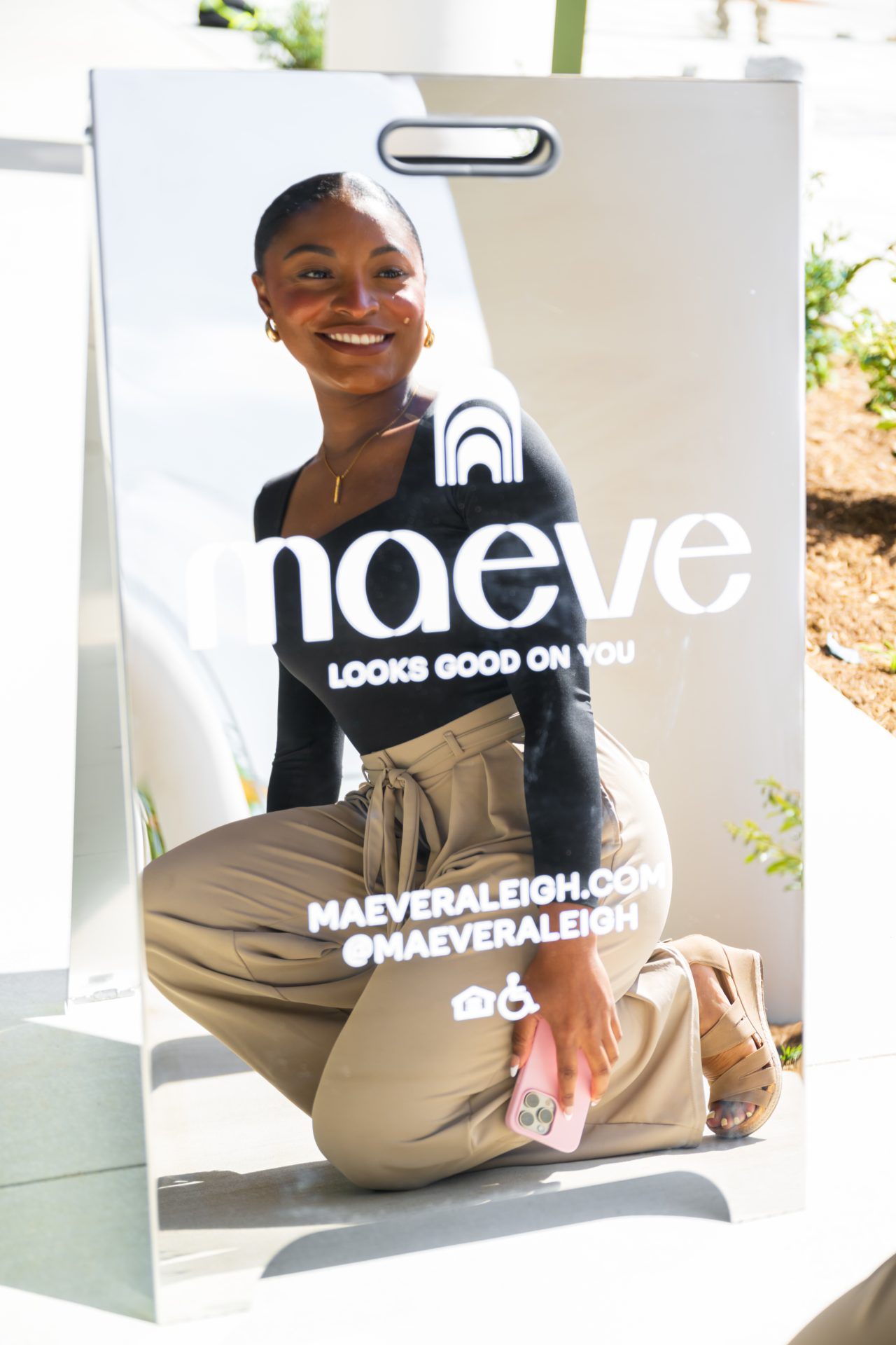 Woman holding a Naeve retail brand lookbook outside an apartment community