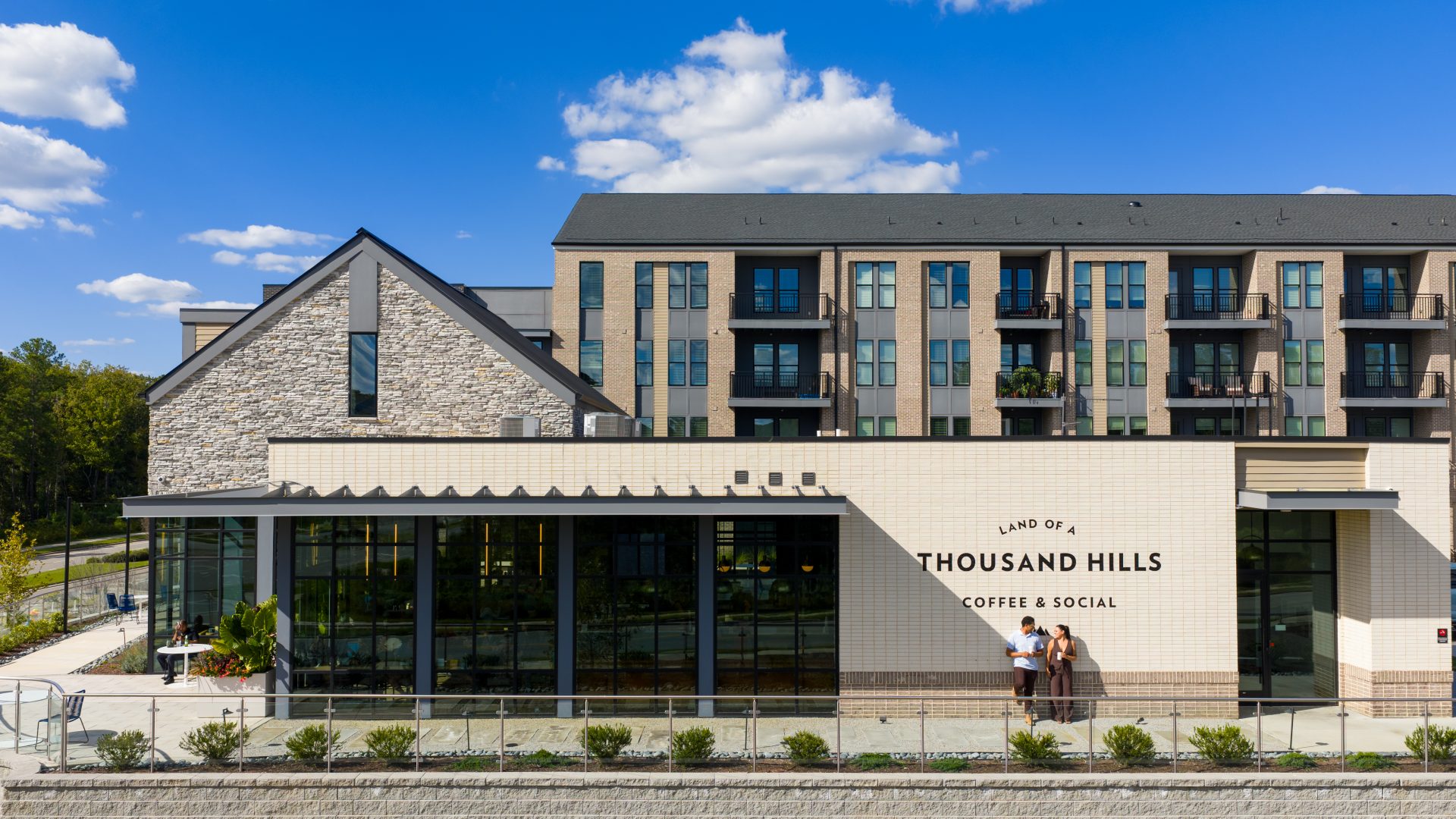 Exterior view of NOVEL Morrisville apartment building under a bright blue sky