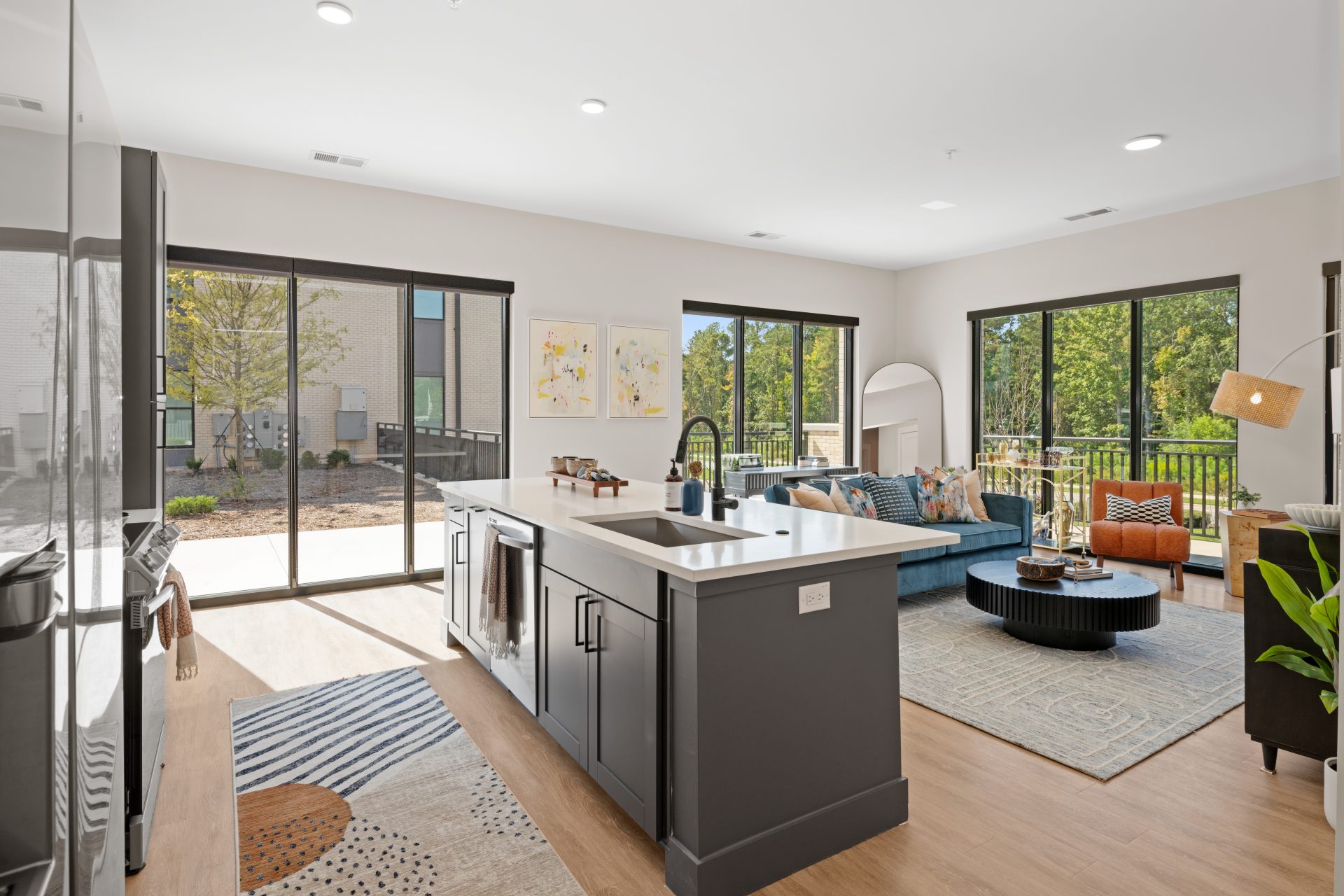 Bright modern apartment kitchen and living area with large sliding glass doors and natural light